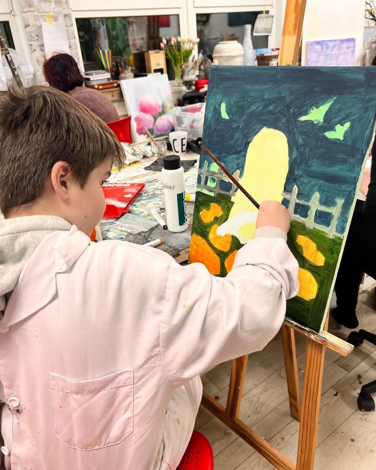 Kinder malen in der Kreativwerkstatt auf Leinwänden